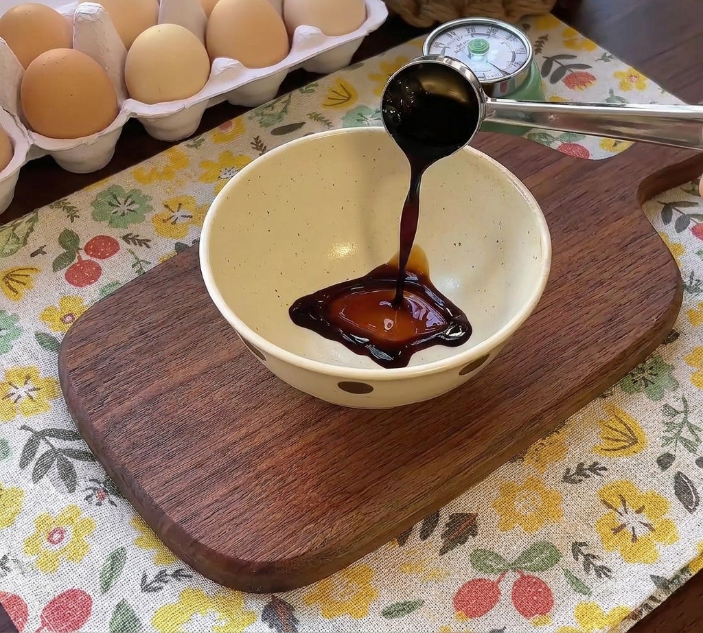 Dunkle Sauce wird in eine Schüssel mit Gewürzen für die Hamburg-Steak-Glasur gegossen.