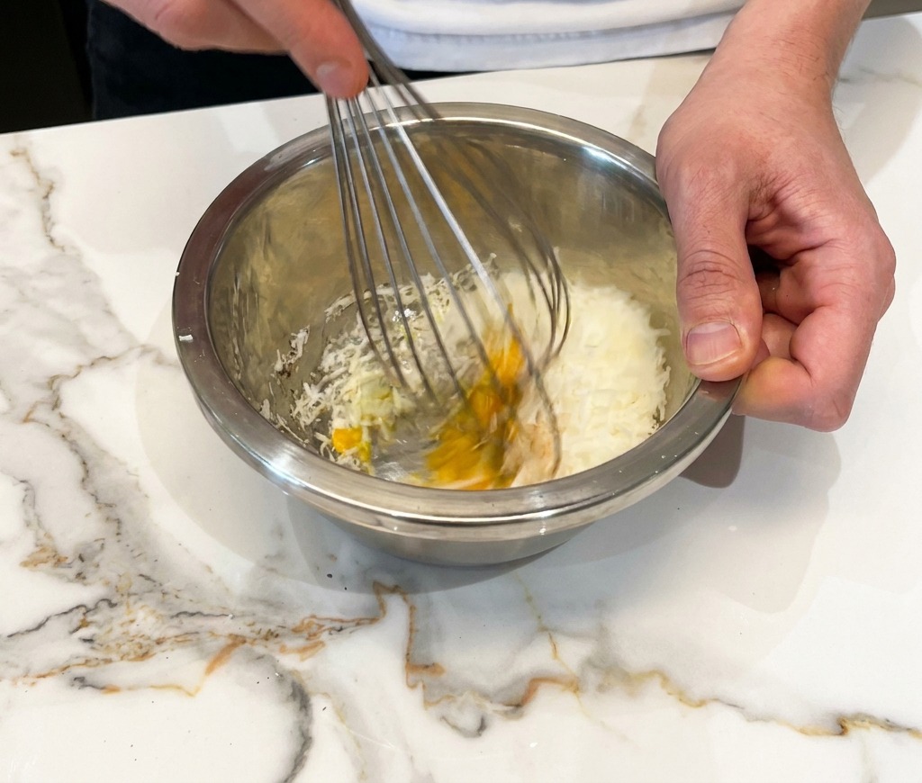 Ei, Käse und Pfeffer werden zu einer dicken Paste verrührt.
