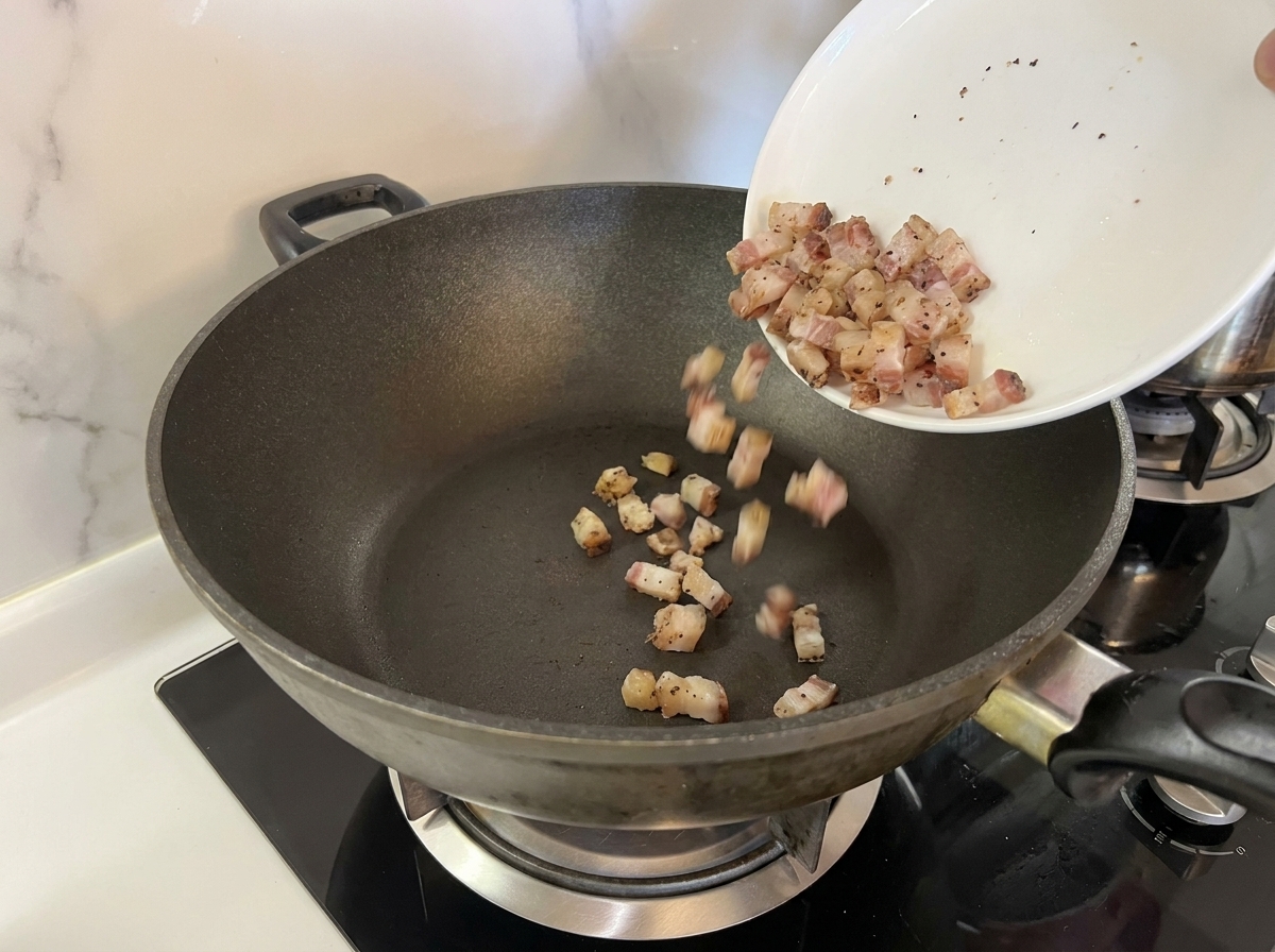 Guanciale-Würfel werden in eine noch kalte Pfanne gegeben.