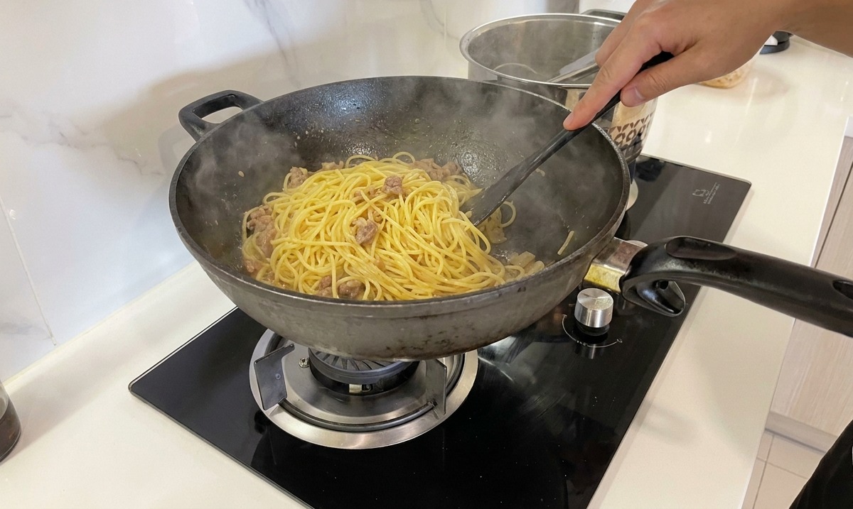 Die Spaghetti werden in der Pfanne kräftig geschwenkt, bis die Sauce glänzt.