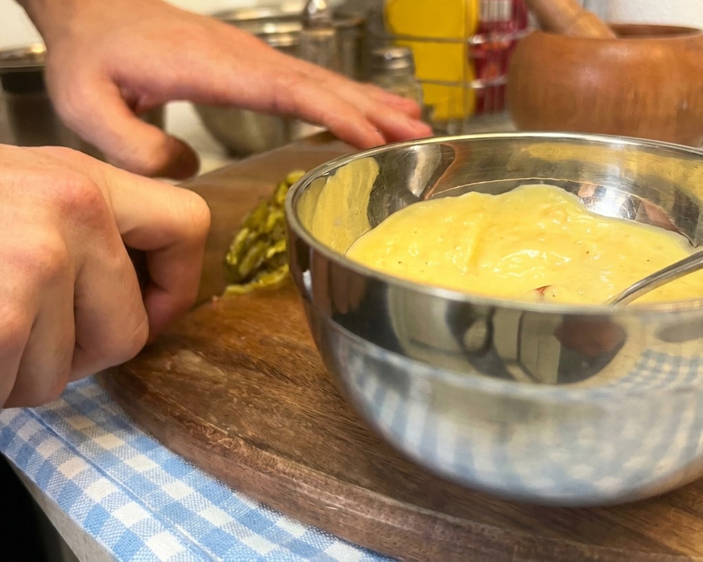Fein gewürfelte Gewürzgurken werden zu einer Mischung aus Mayonnaise, Senf und Ketchup für die Burgersoße gegeben.
