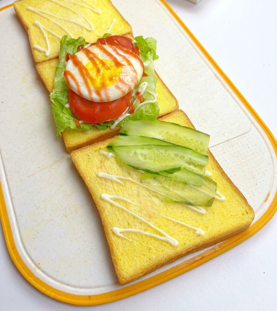 Dünne Gurkenscheiben werden diagonal auf einer weiteren Toastscheibe angeordnet.