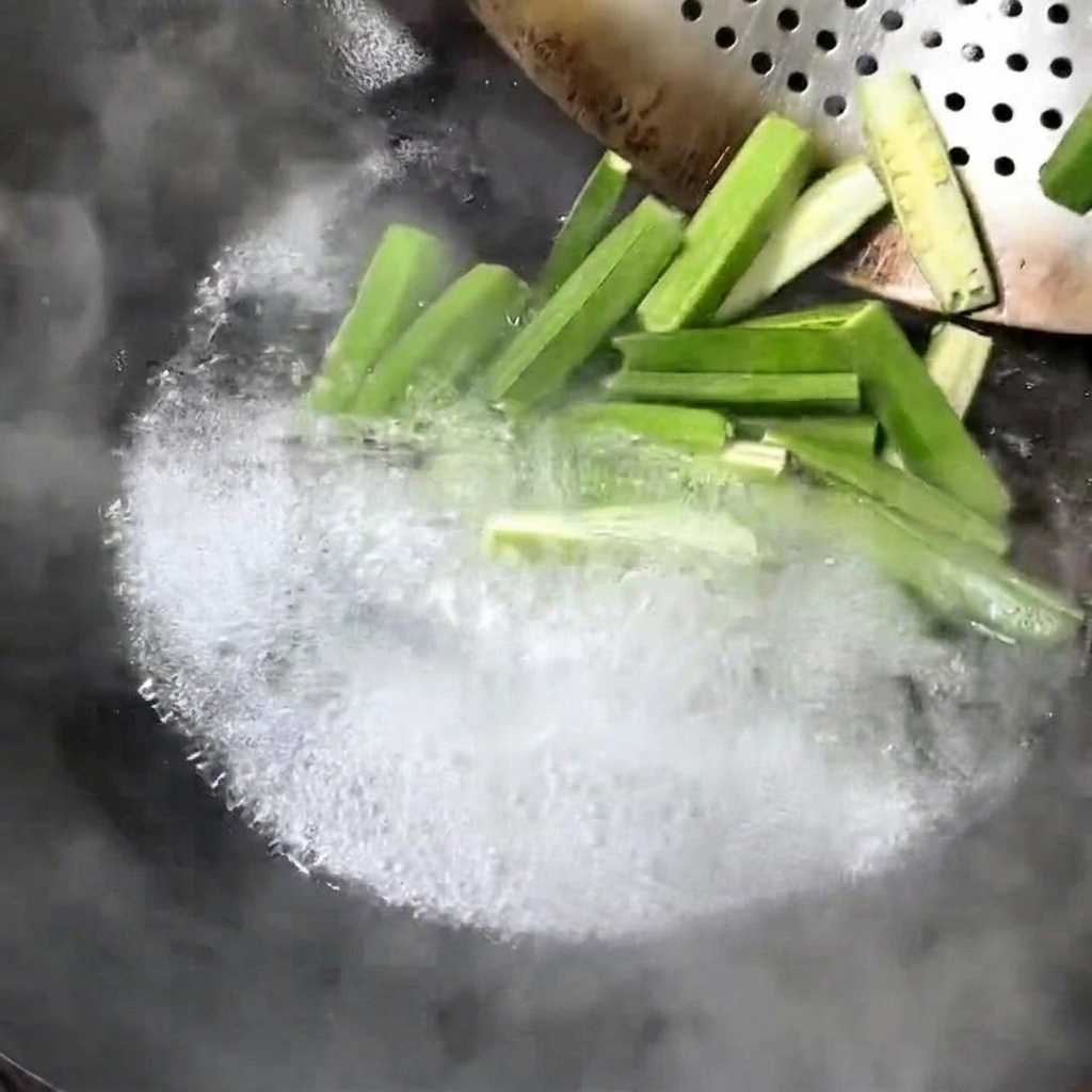 Frische Okrastücke kochen in einem Wok.