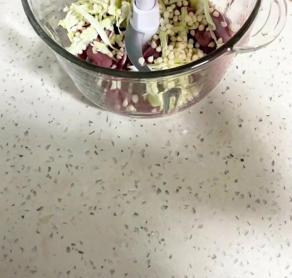 Entenfleisch und Okrasamen werden in einer Küchenmaschine vermengt.