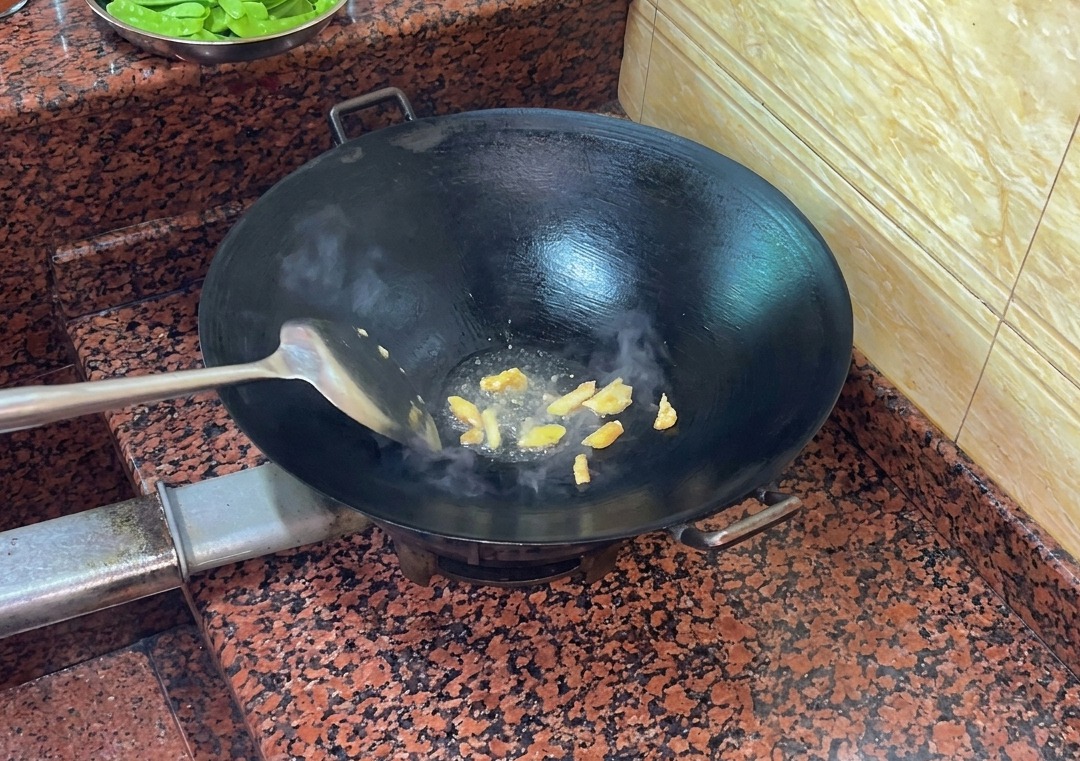 Entenhaut brät in einem heißen, trockenen Wok und gibt flüssiges Fett ab.