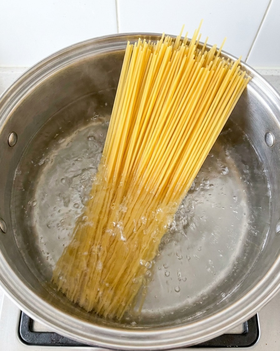 Spaghetti kochen in einem großen Topf mit siedendem Wasser.