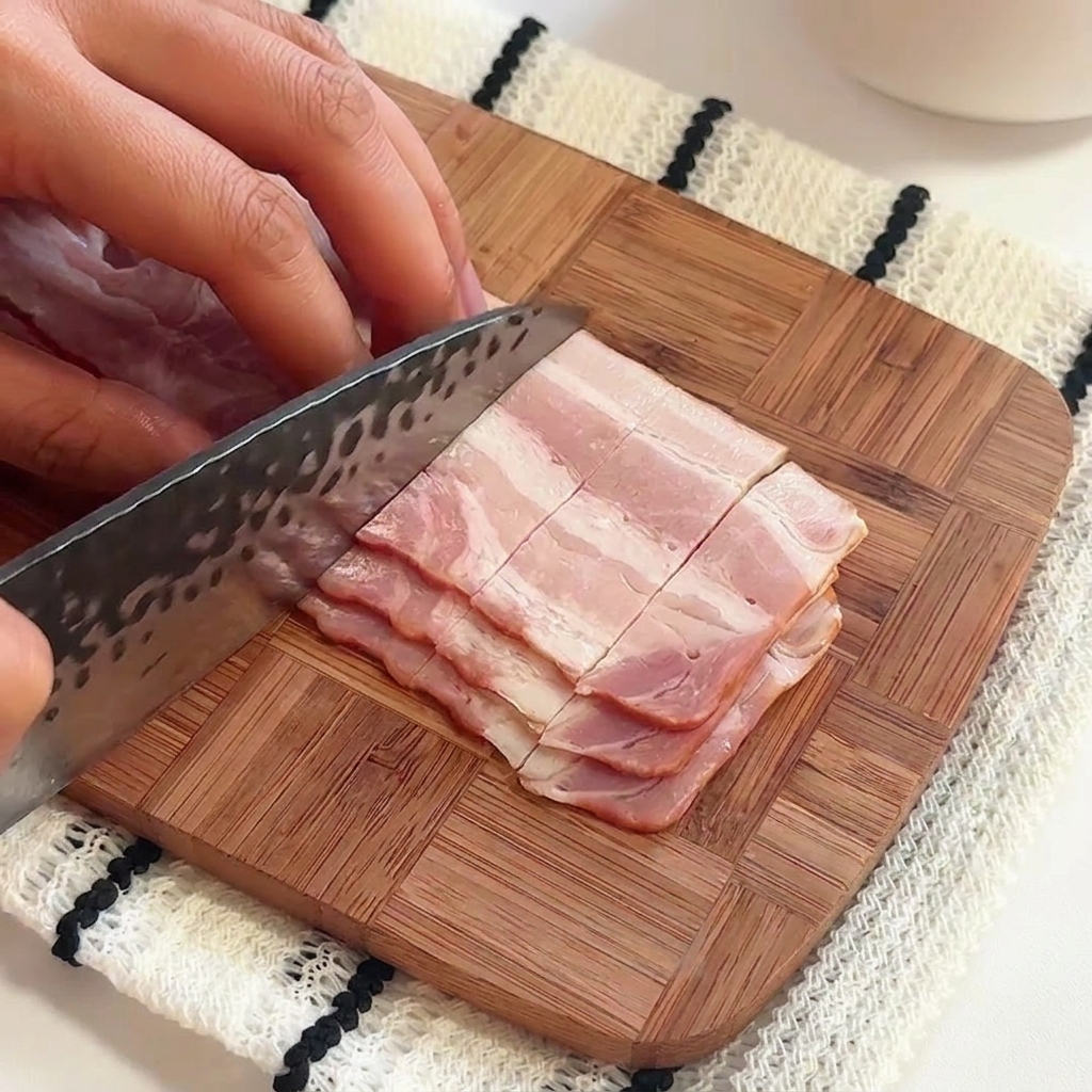 Eine Hand gibt Salz und Olivenöl in einen Topf mit sprudelnd kochendem Wasser.