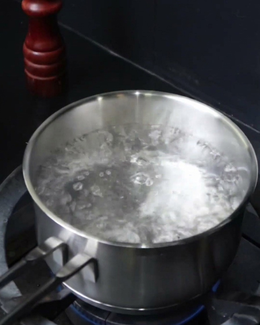 Spaghetti werden in einen Topf mit kochendem Salzwasser gegeben.