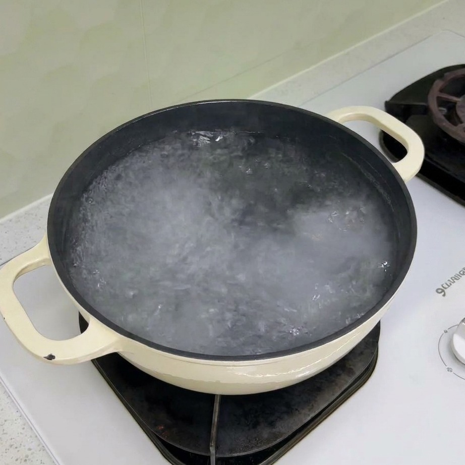 Trockene Fusilli-Nudeln werden in einen Topf mit kochendem Wasser gegeben.