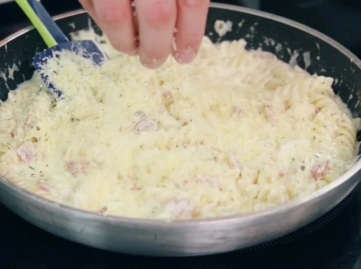 Zwiebeln und Knoblauch garen zusammen mit dem Speck in einer Pfanne.