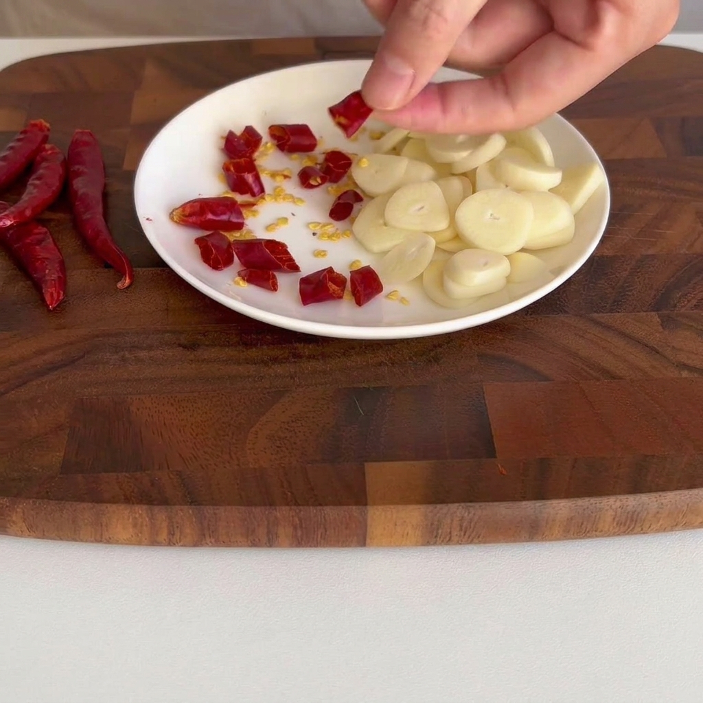 In kleine Stücke geschnittene getrocknete Chilischoten auf einem kleinen weißen Teller.