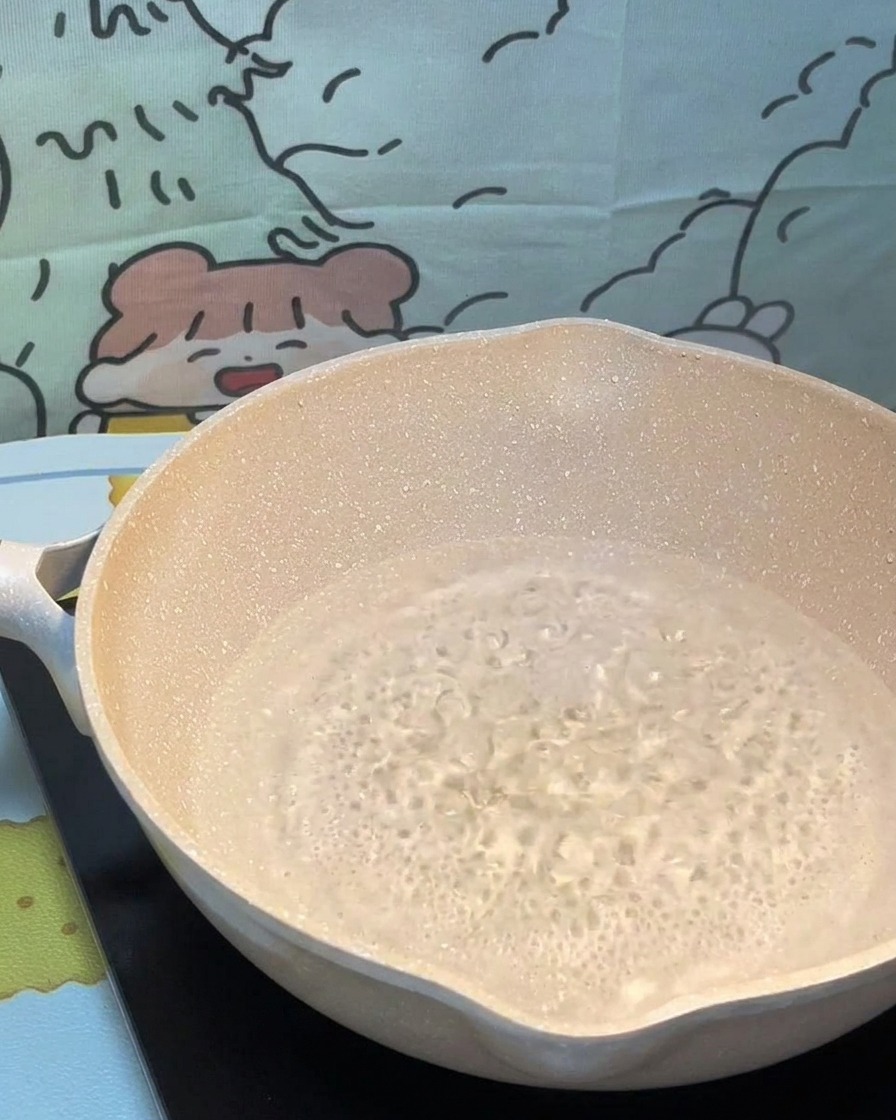 Trockene Pasta wird vorsichtig in einen Topf mit sprudelnd kochendem Wasser gegeben.