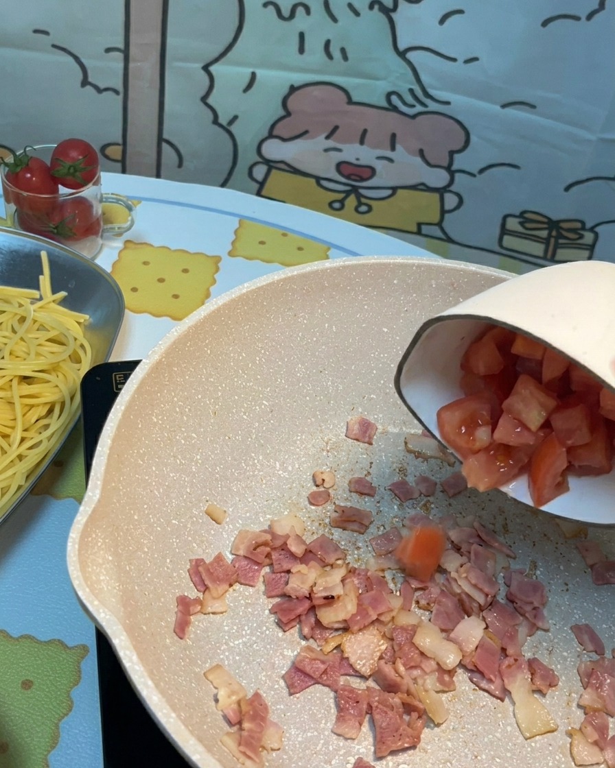 Gehackte frische Tomaten wurden in die Pfanne zu den knusprigen Speckstücken gegeben.