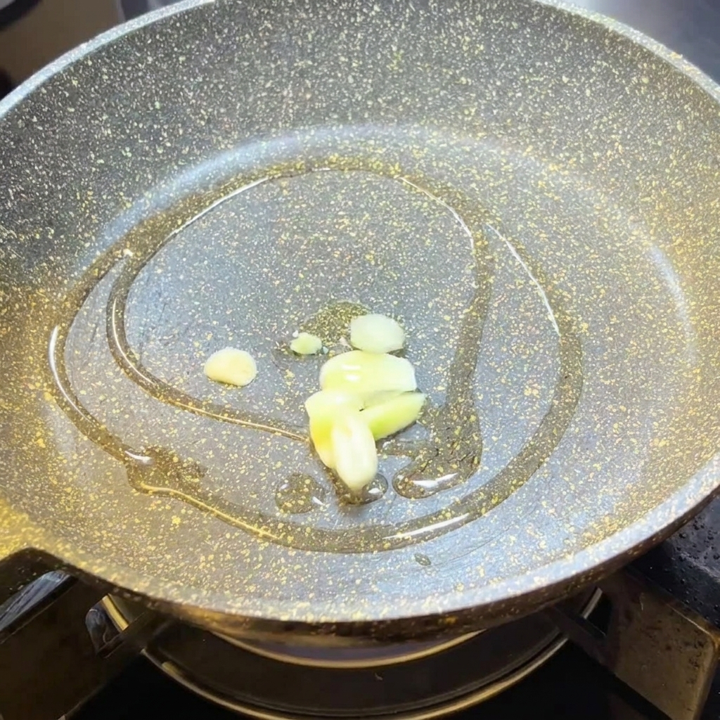Knoblauchscheiben braten in heißem Olivenöl in einer Pfanne.