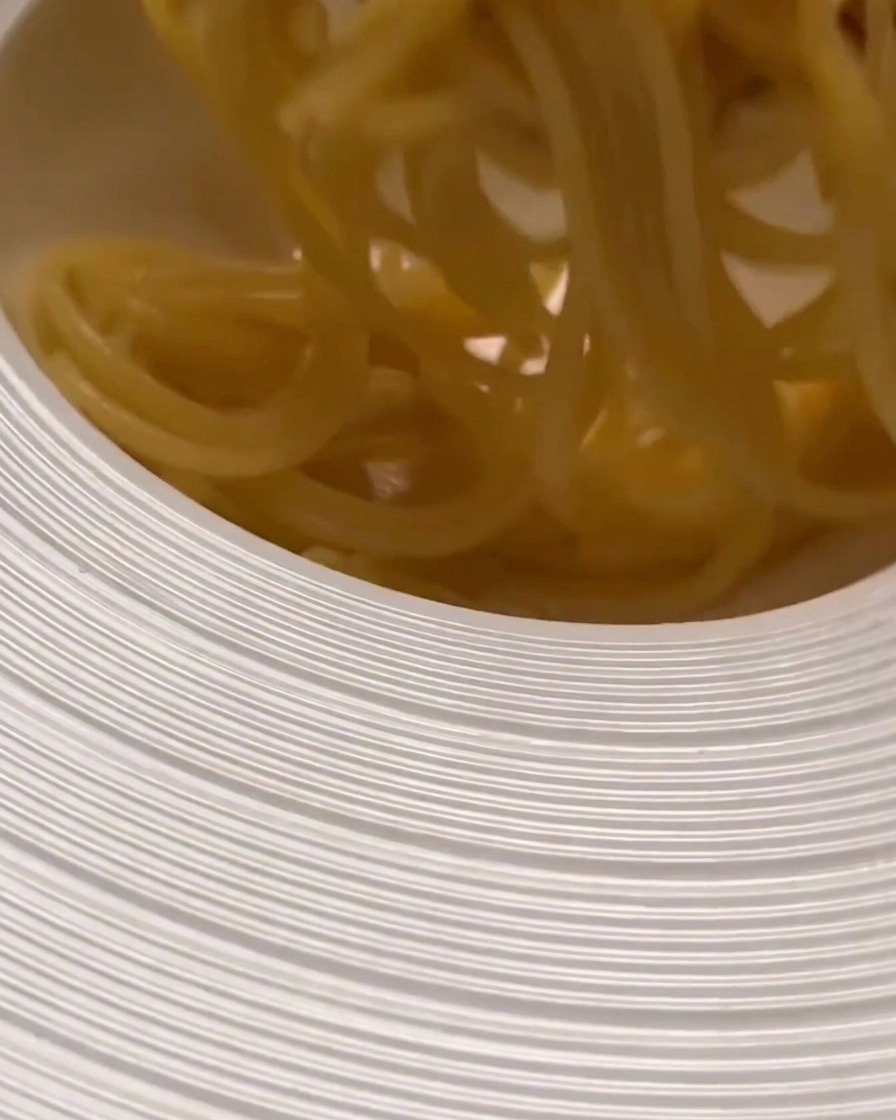 Gekochte Pasta wird in eine große Schüssel gegeben, um sie mit der Sauce zu vermengen.