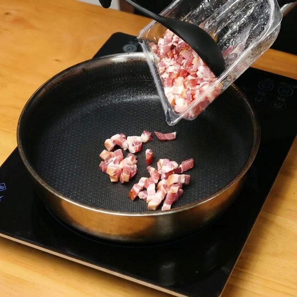 Gehackte Speckwürfel braten in einer heißen Pfanne und geben Fett ab.