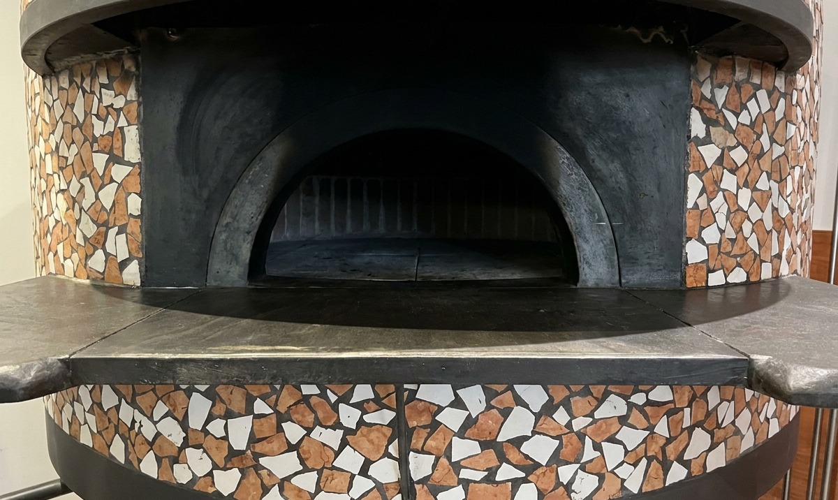 Pizza backt im Ofen, der Rand geht auf und wird braun.