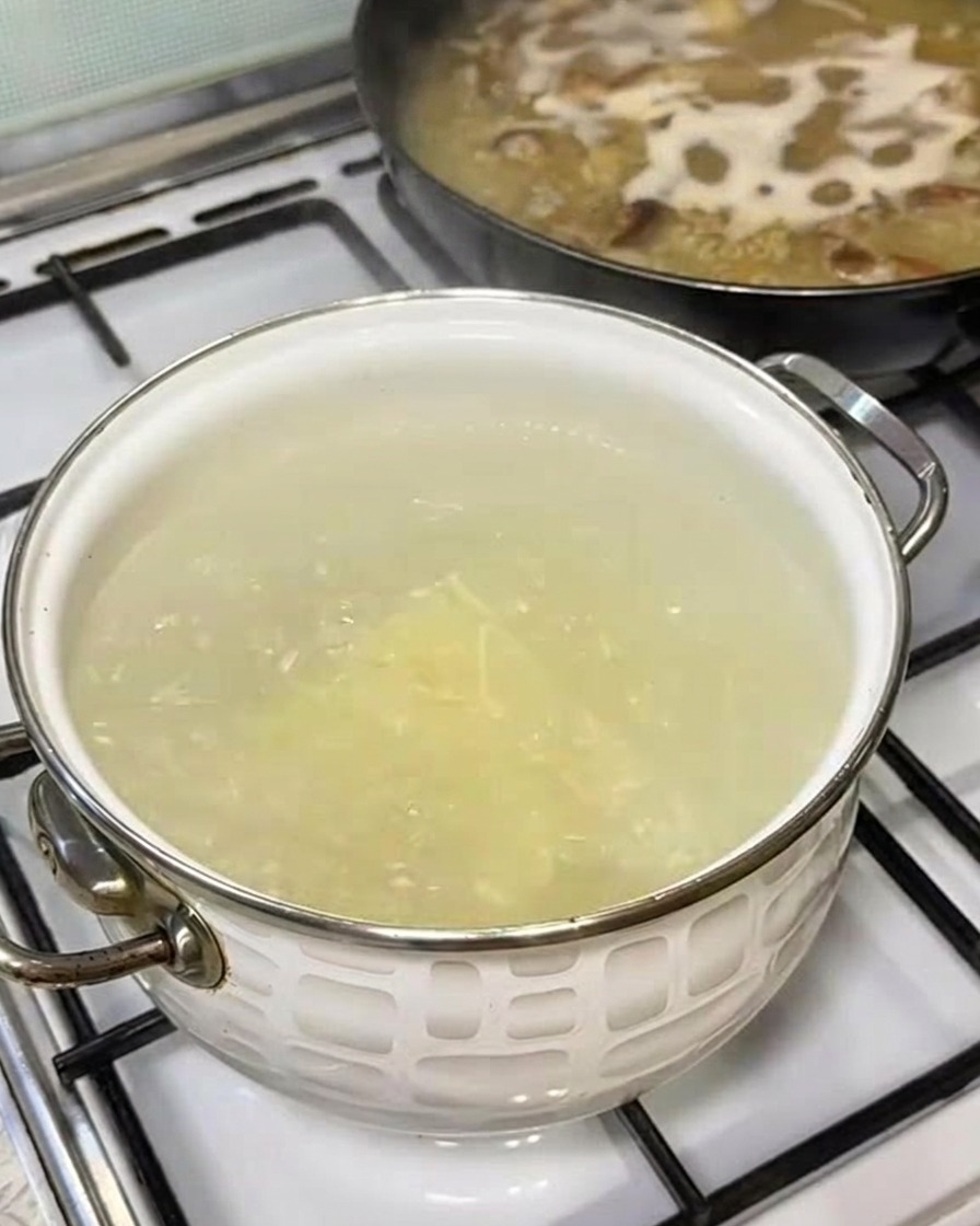 Ramen-Nudeln werden in einen Topf mit sprudelnd kochendem Wasser gegeben.