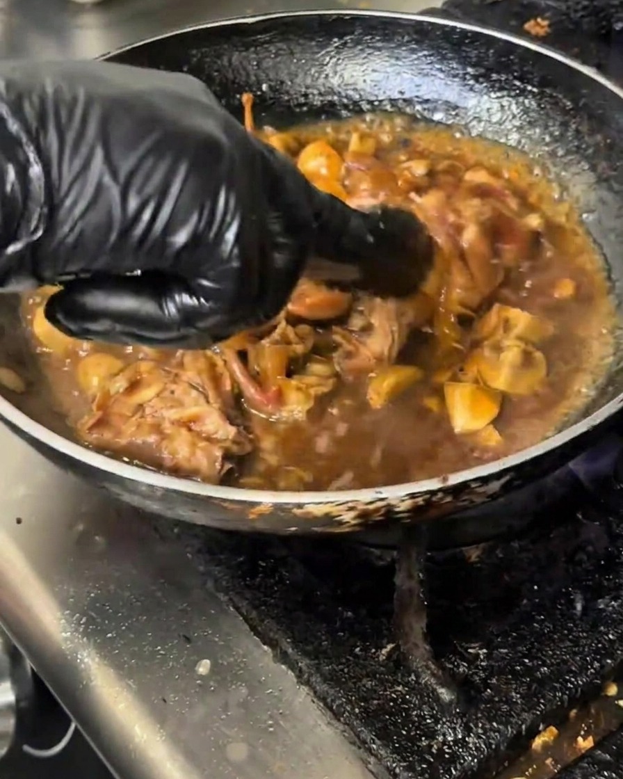 Eine milchige Stärkemischung wird aus einem Messbecher in eine köchelnde Pfanne mit Rindfleisch und Pilzen gegossen.