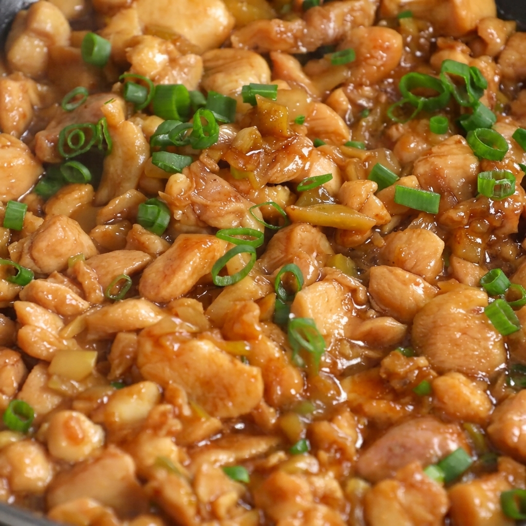 Das fertige Pfannengericht mit Hähnchen und Kohl, in der Pfanne mit frisch gehackten Frühlingszwiebeln garniert.