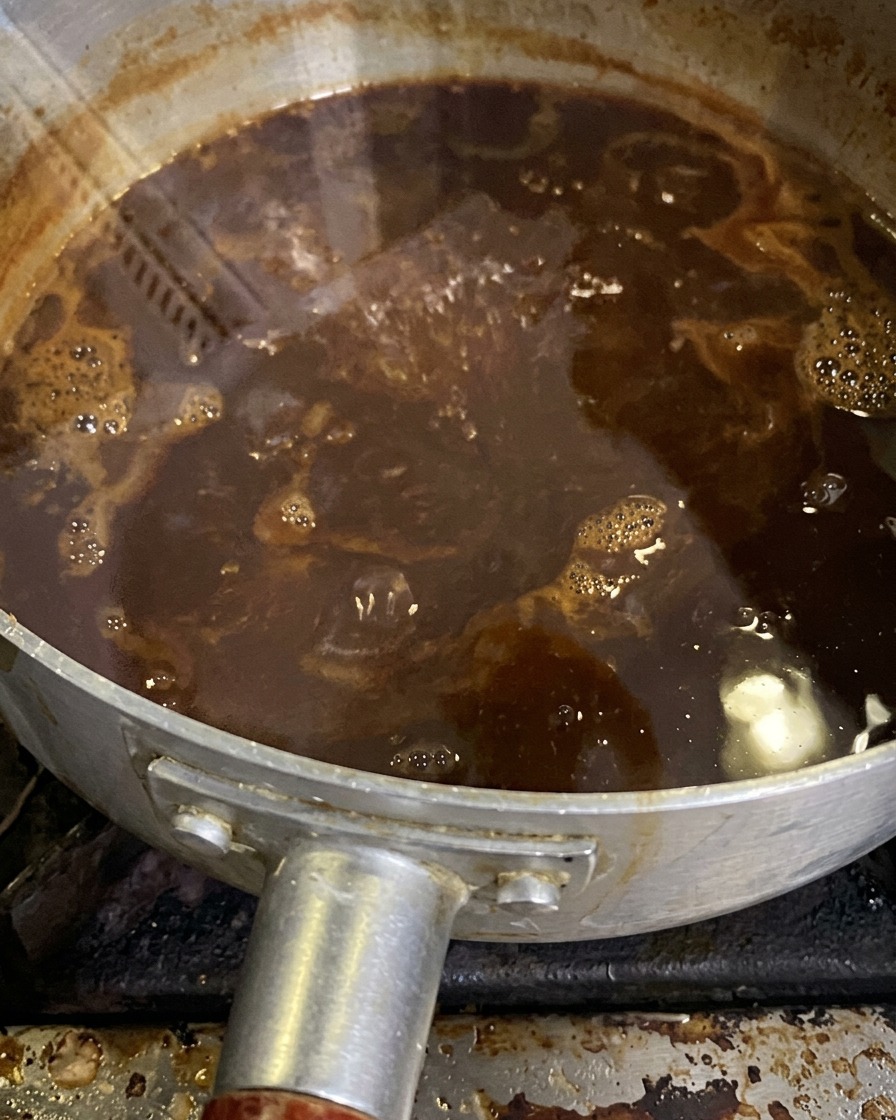 Die Miso-Sauce blubbert sanft in einem Topf, während sie köchelt und reduziert.