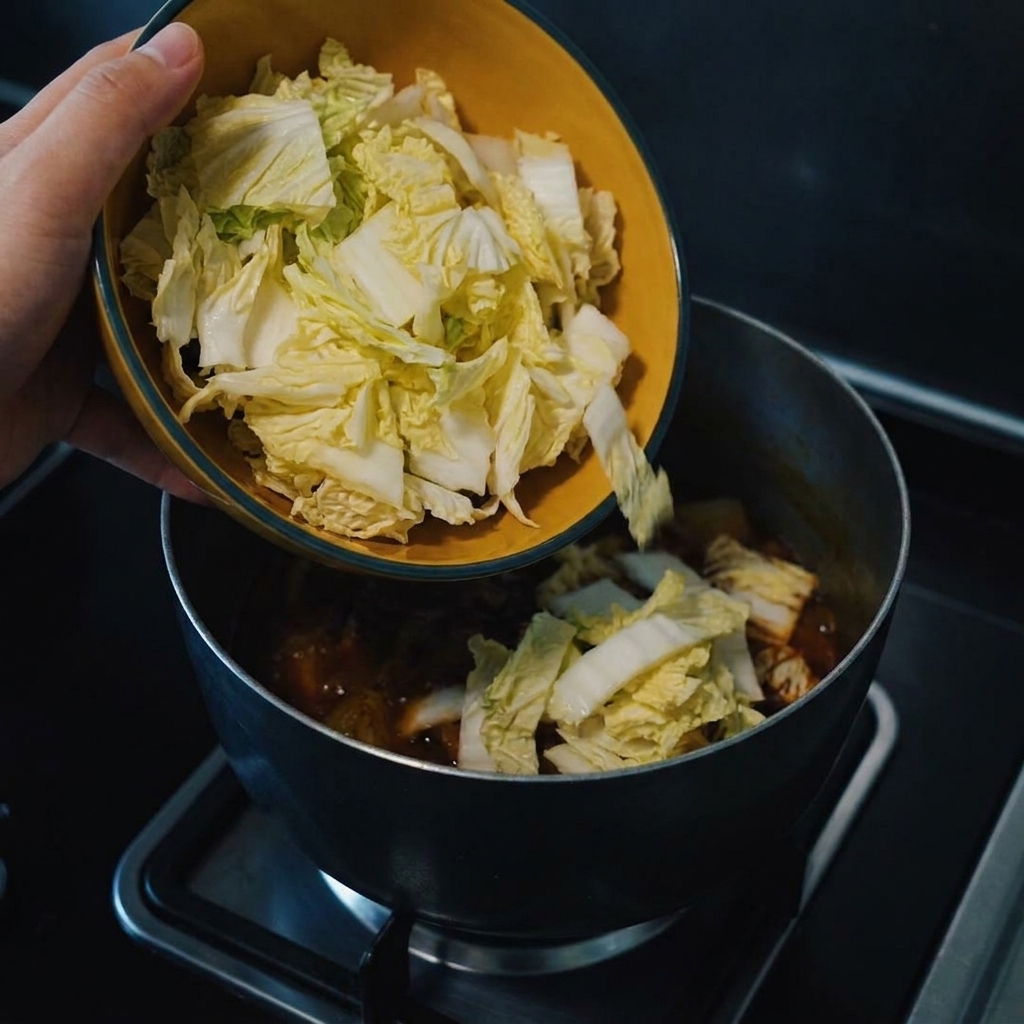 Frisch gehackter Kohl wird in den köchelnden Currytopf gegeben.