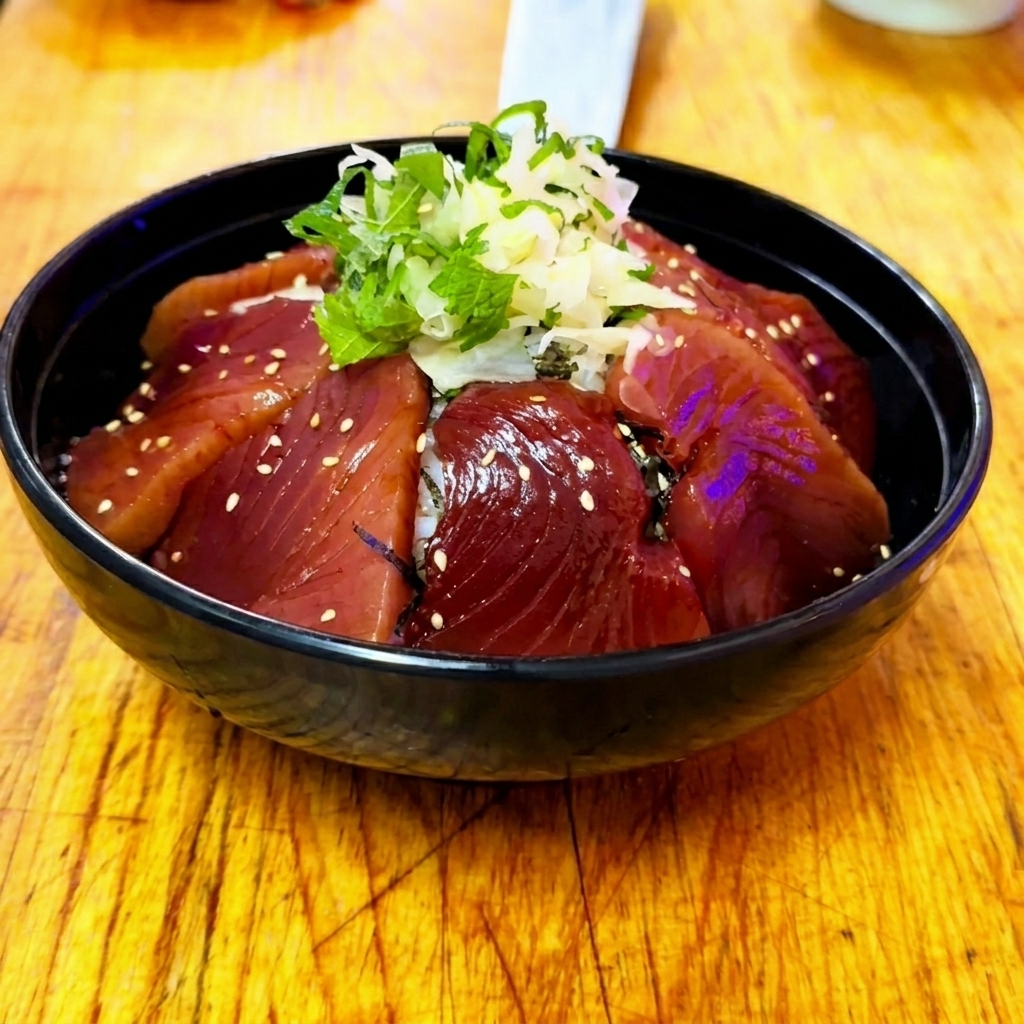 Eine fertige Zuke Don-Reisschale mit mariniertem Thunfisch, Ingwer, Shiso und einer leichten Bestreuung mit weißen Sesamsamen.