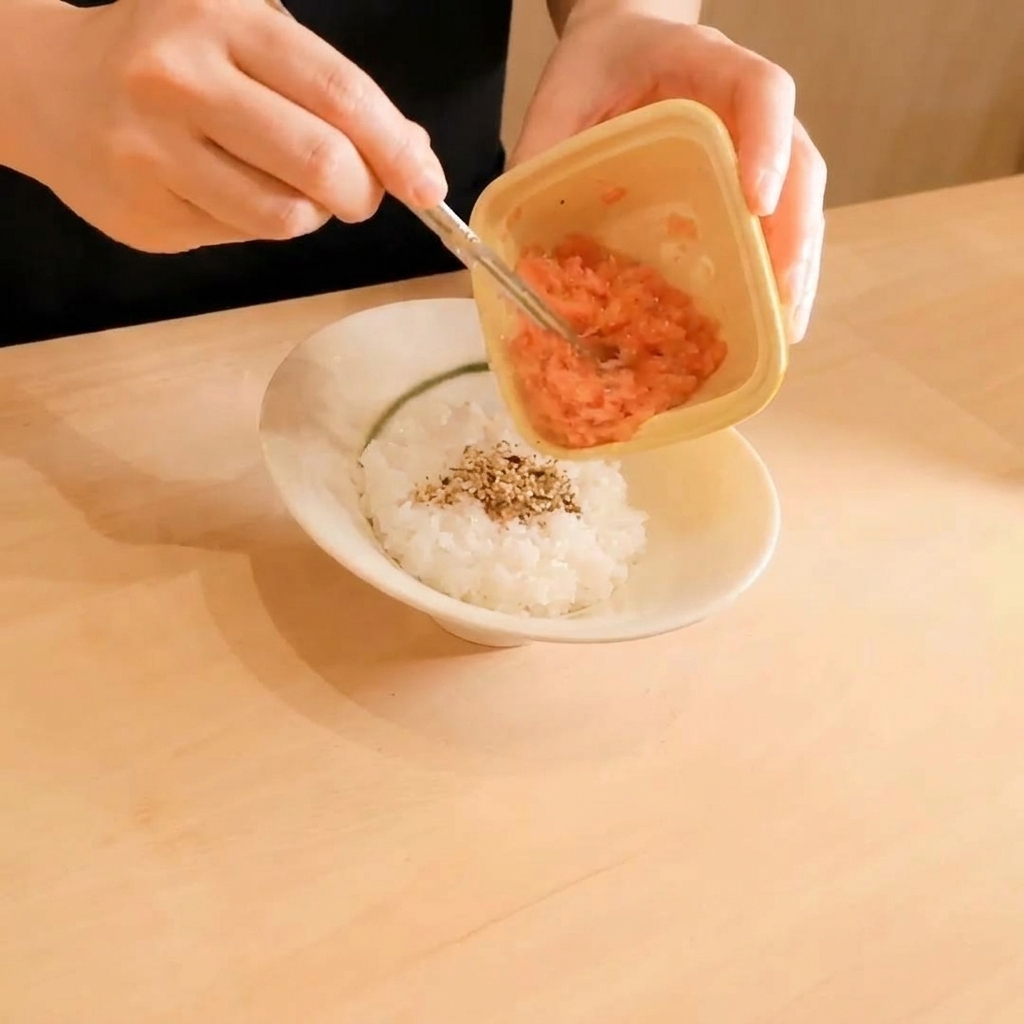 Gehackter Thunfisch wird auf den Reis gegeben.