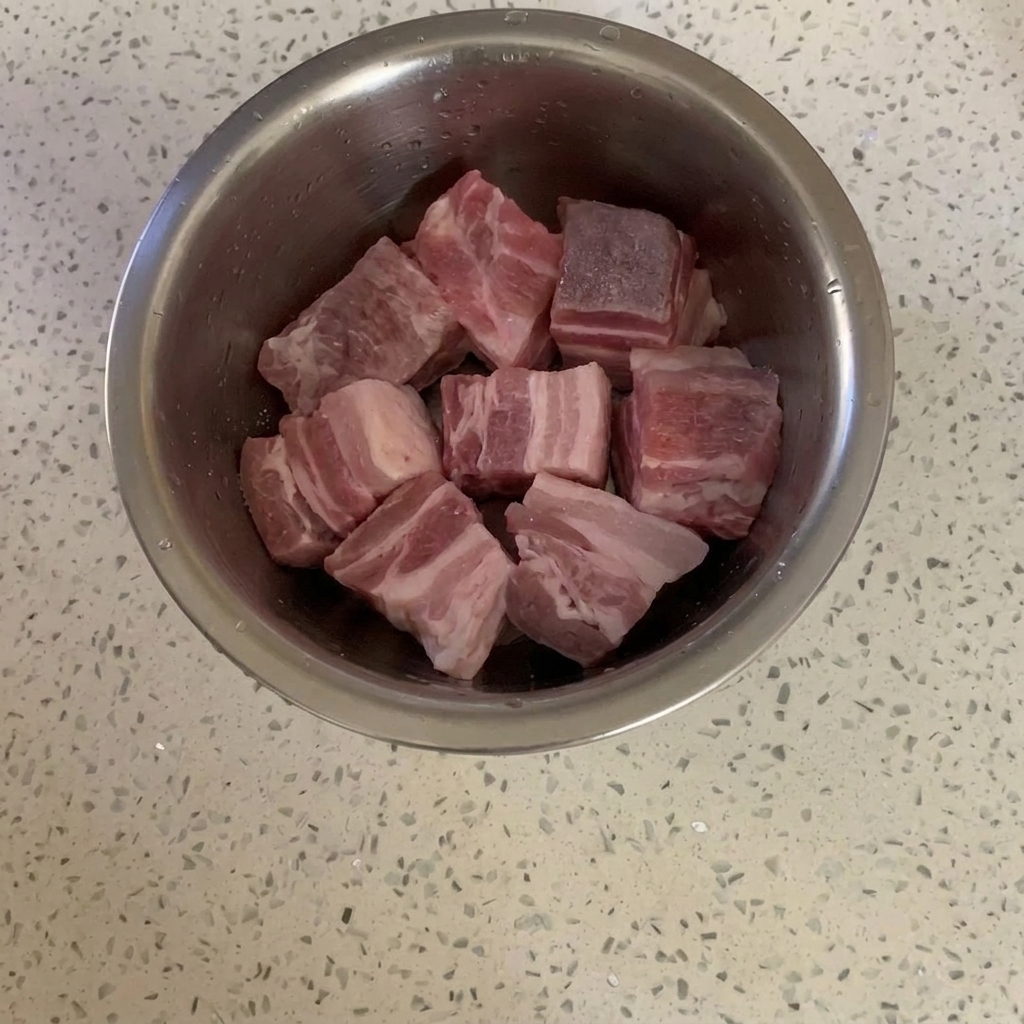 Schweinebauchwürfel in einer Schüssel mit einer leichten Schicht Zucker.