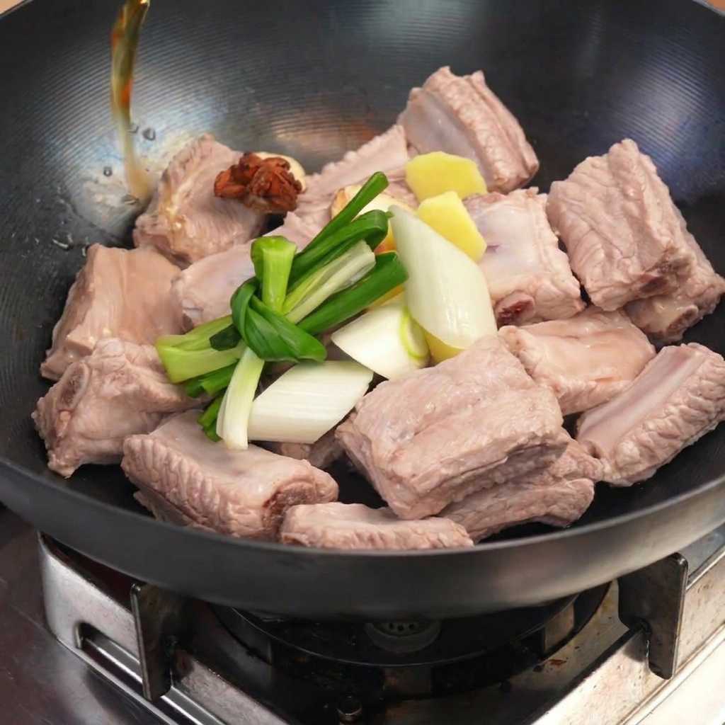Vorgekochte Rippchen im Wok mit Frühlingszwiebeln, Ingwer und Sternanis.
