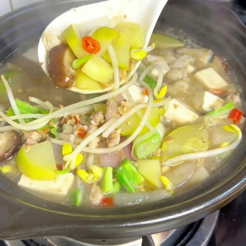 Weiche Tofuwürfel, die in den Topf mit dem köchelnden Eintopf gelegt werden.