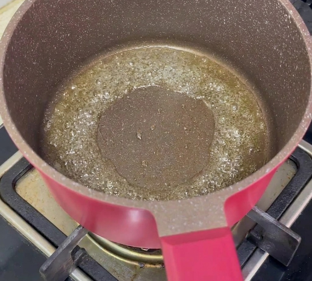 Gewürfelte Karotten und gehackte Frühlingszwiebeln braten in einer Pfanne mit heißem Öl.