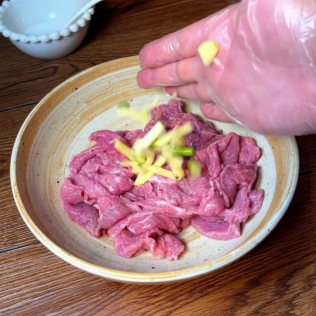 Hand mit Handschuh massiert Rindfleisch mit Gewürzen.