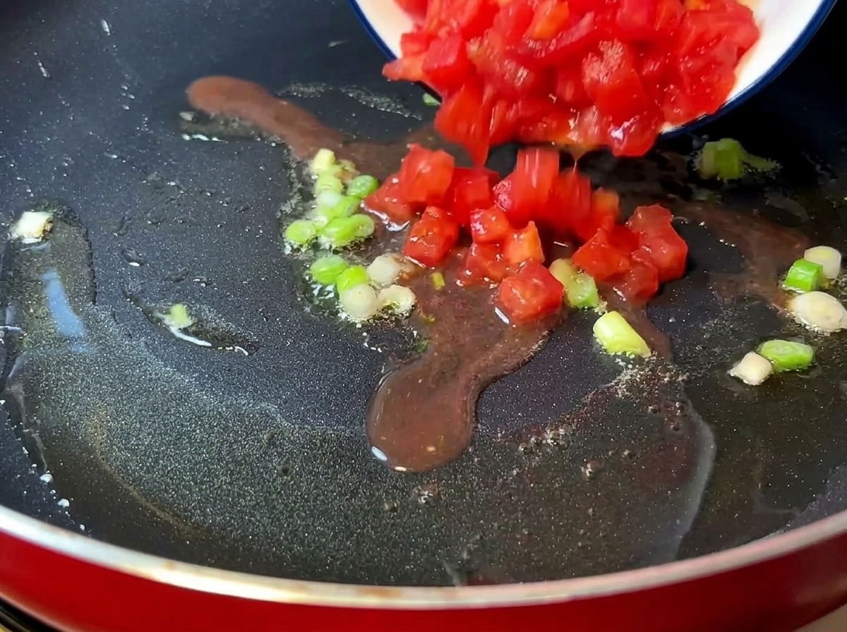 Gehackte Tomaten in einer Pfanne, bis sie weich werden.