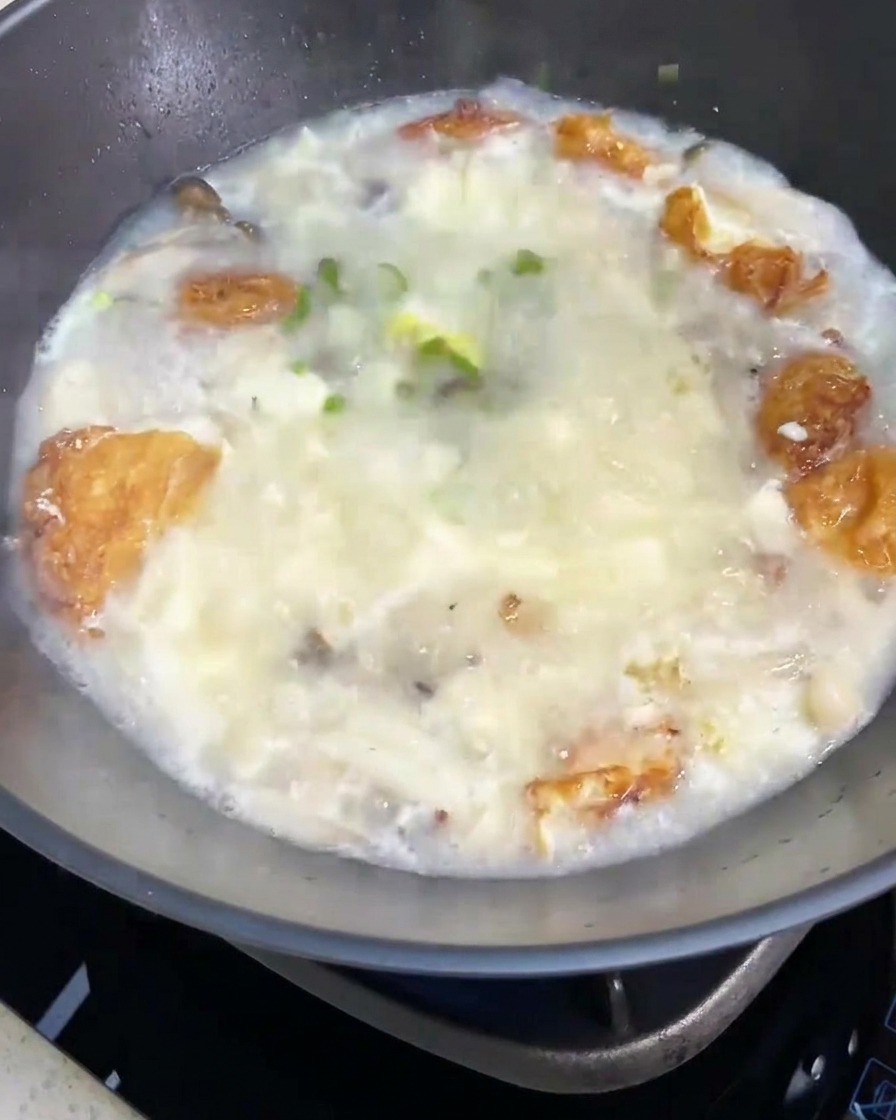 Die fertige Pilz-Tofu-Suppe wird mit einer Handvoll frischer Frühlingszwiebeln garniert.