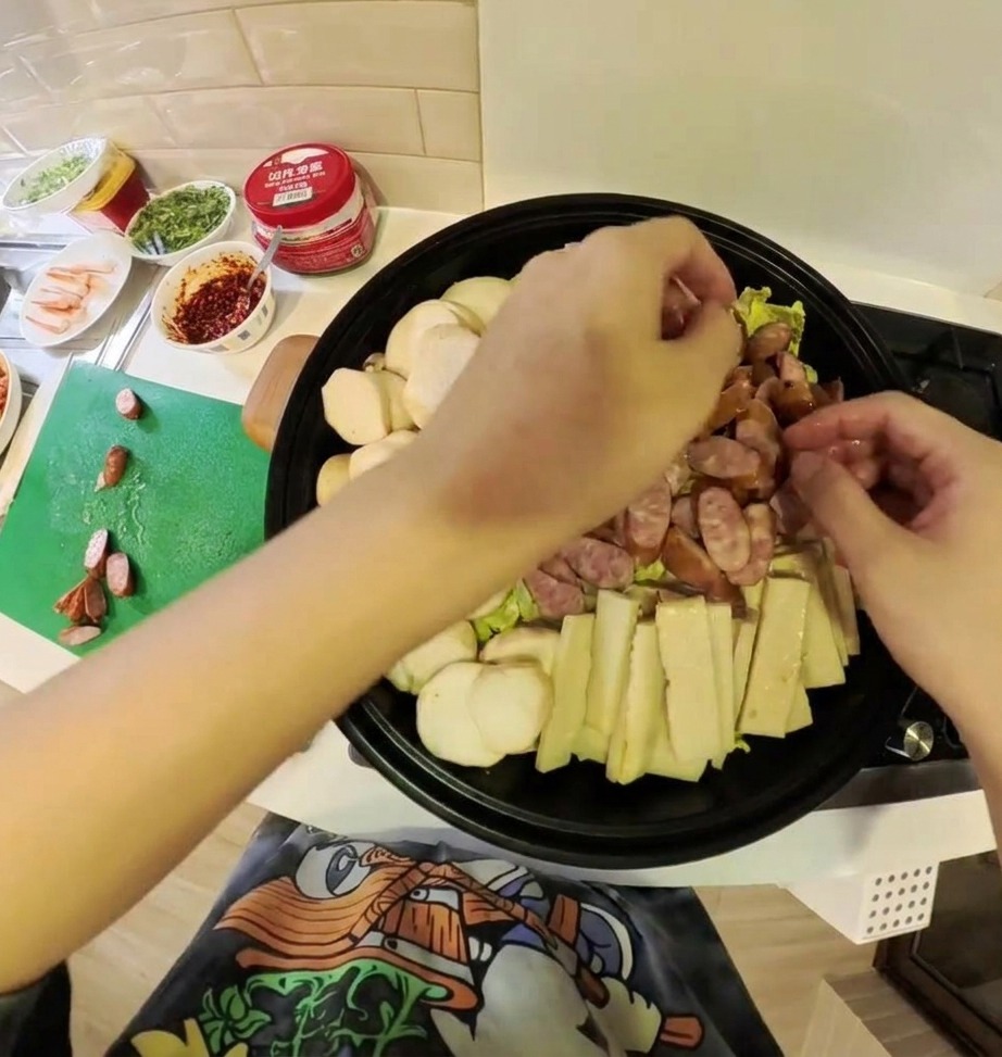 Eine Vielzahl von vorbereiteten Zutaten für den Armee-Eintopf, einschließlich Kimchi, Fleisch und Gemüse, wunderschön in einem flachen Kochtopf arrangiert.