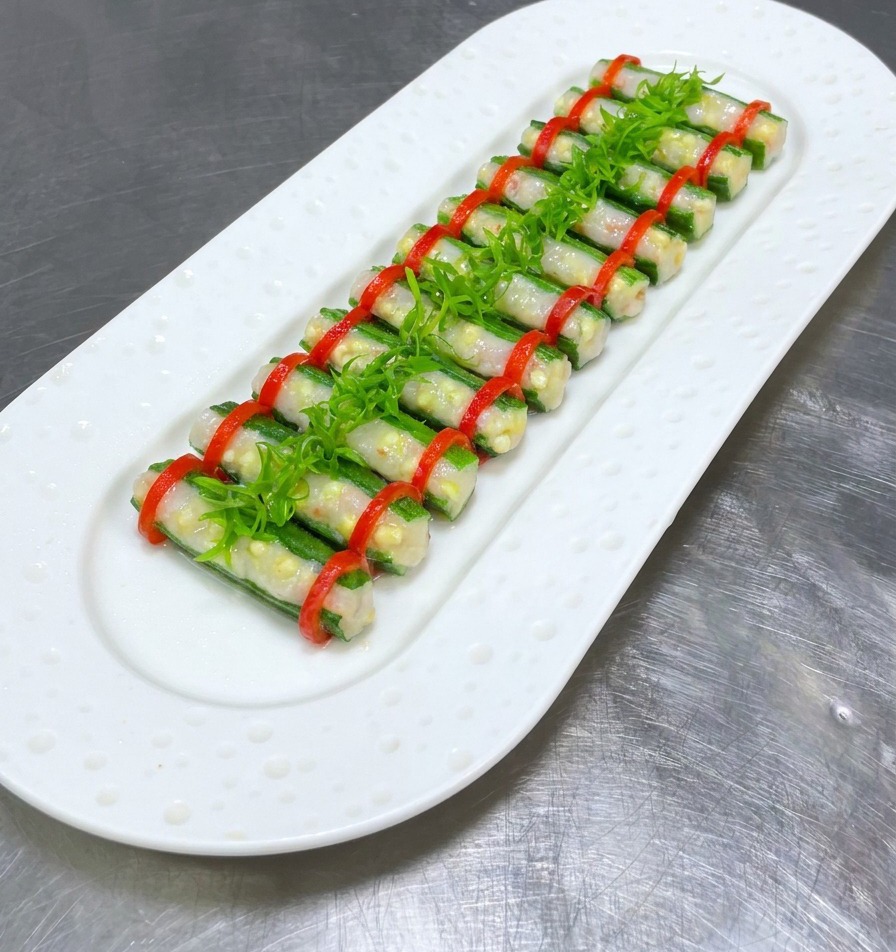Gedämpfte gefüllte Okra, getoppt mit einer mittigen Reihe aus leuchtend grünen Frühlingszwiebelstreifen.
