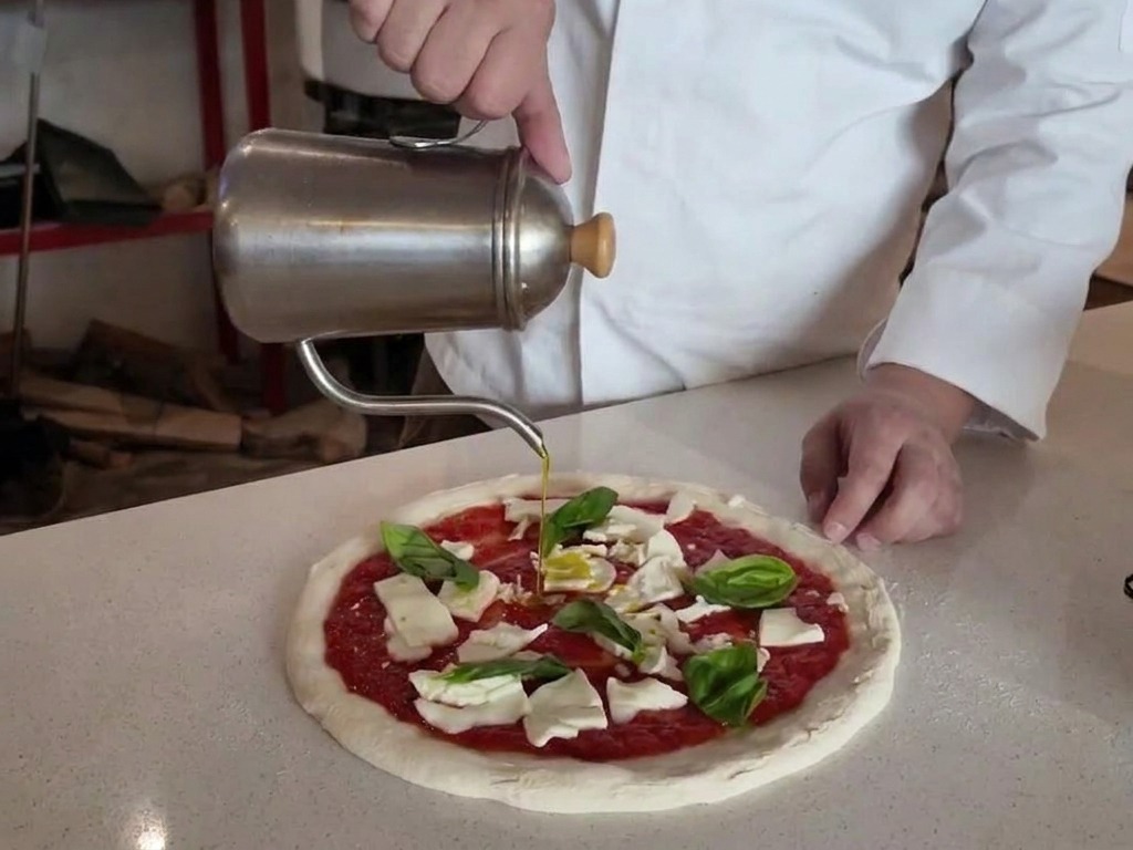Ein Olivenölspender gießt Öl über eine Pizza, die mit Tomatensauce, Mozzarella und Basilikum belegt ist.