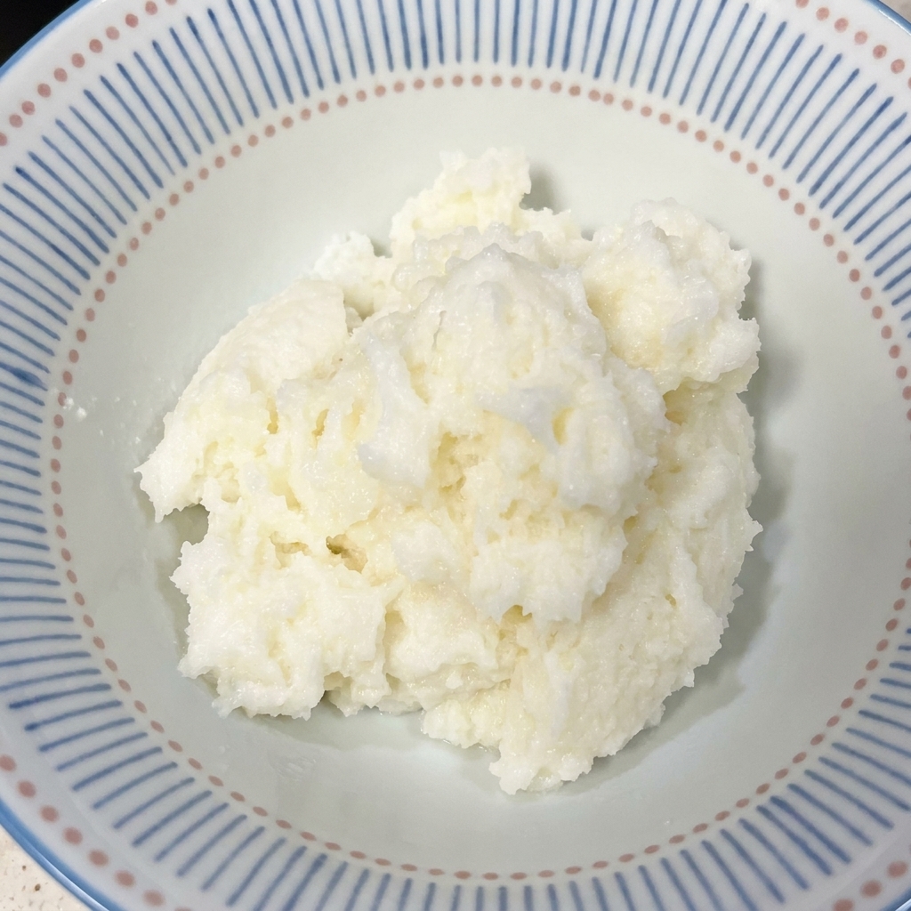 Nahaufnahme einer Keramikschale mit blauem Rand, gefüllt mit frisch gekochtem weißem Reis.