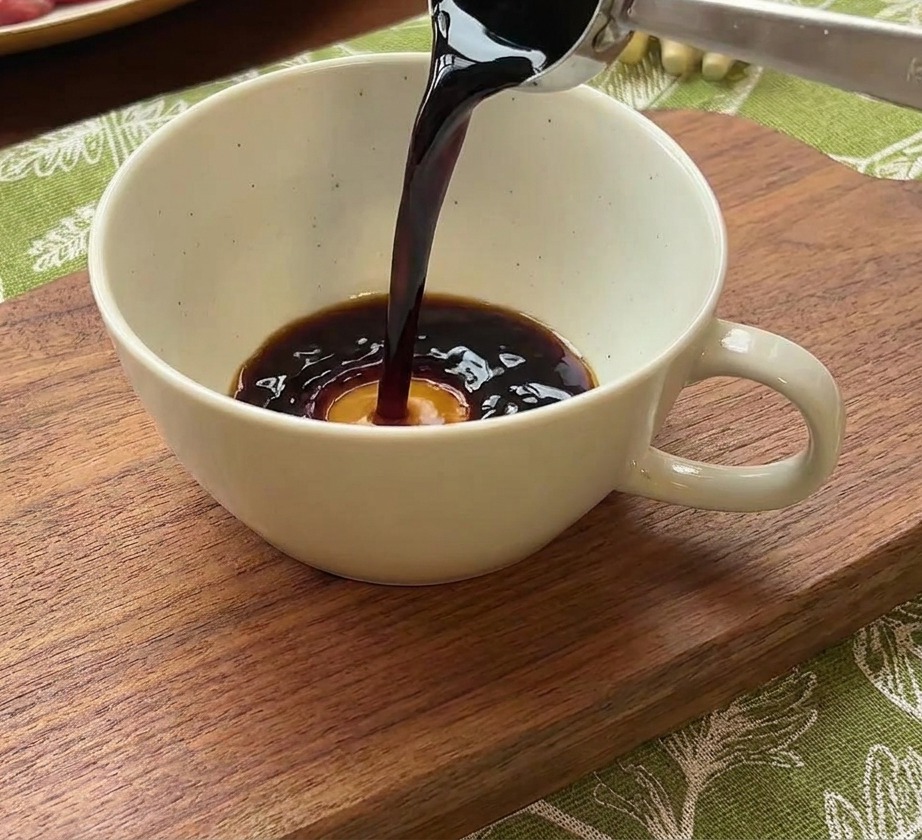 Sojasauce wird in eine Schüssel mit Wasser und roter Chilipaste gegossen.
