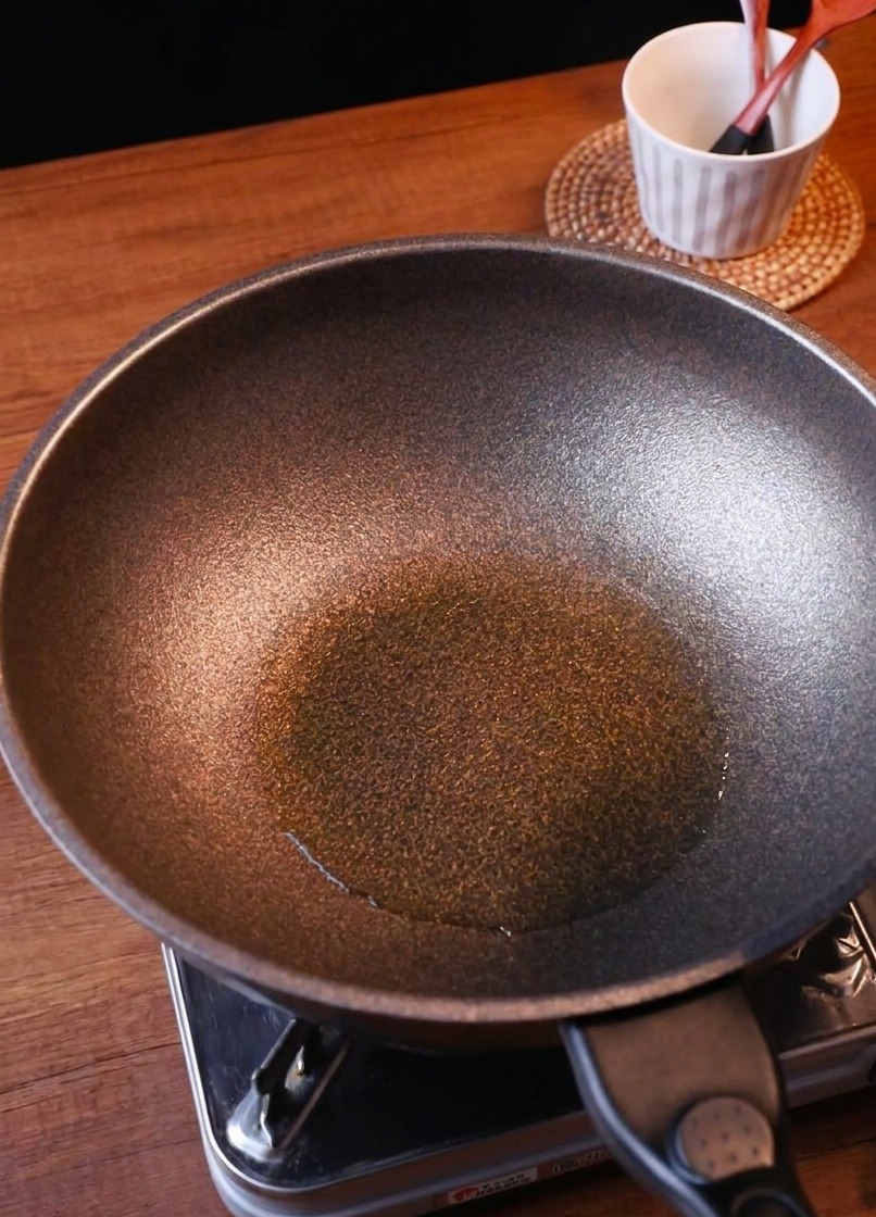 Frisch geschnittene Zwiebeln und eine Portion gehacktes Kimchi werden in eine Pfanne gegeben.