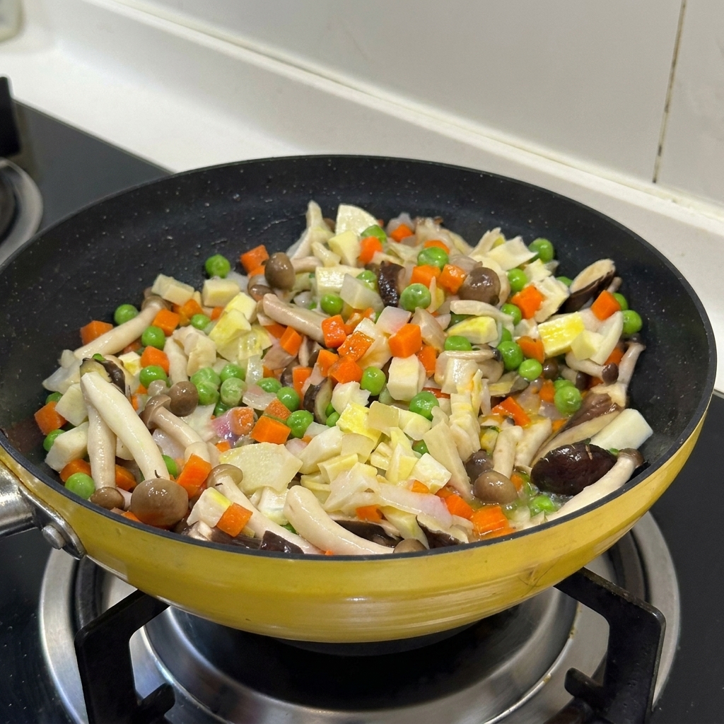 Ein bunter Mix aus Gemüse und Pilzen wird zusammen in einer gelben Pfanne gebraten.