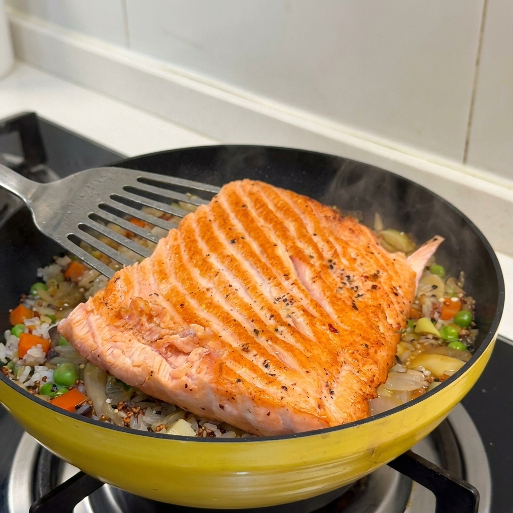 Das goldbraun gebratene Lachsfilet wird auf den Reis und das Gemüse gelegt.