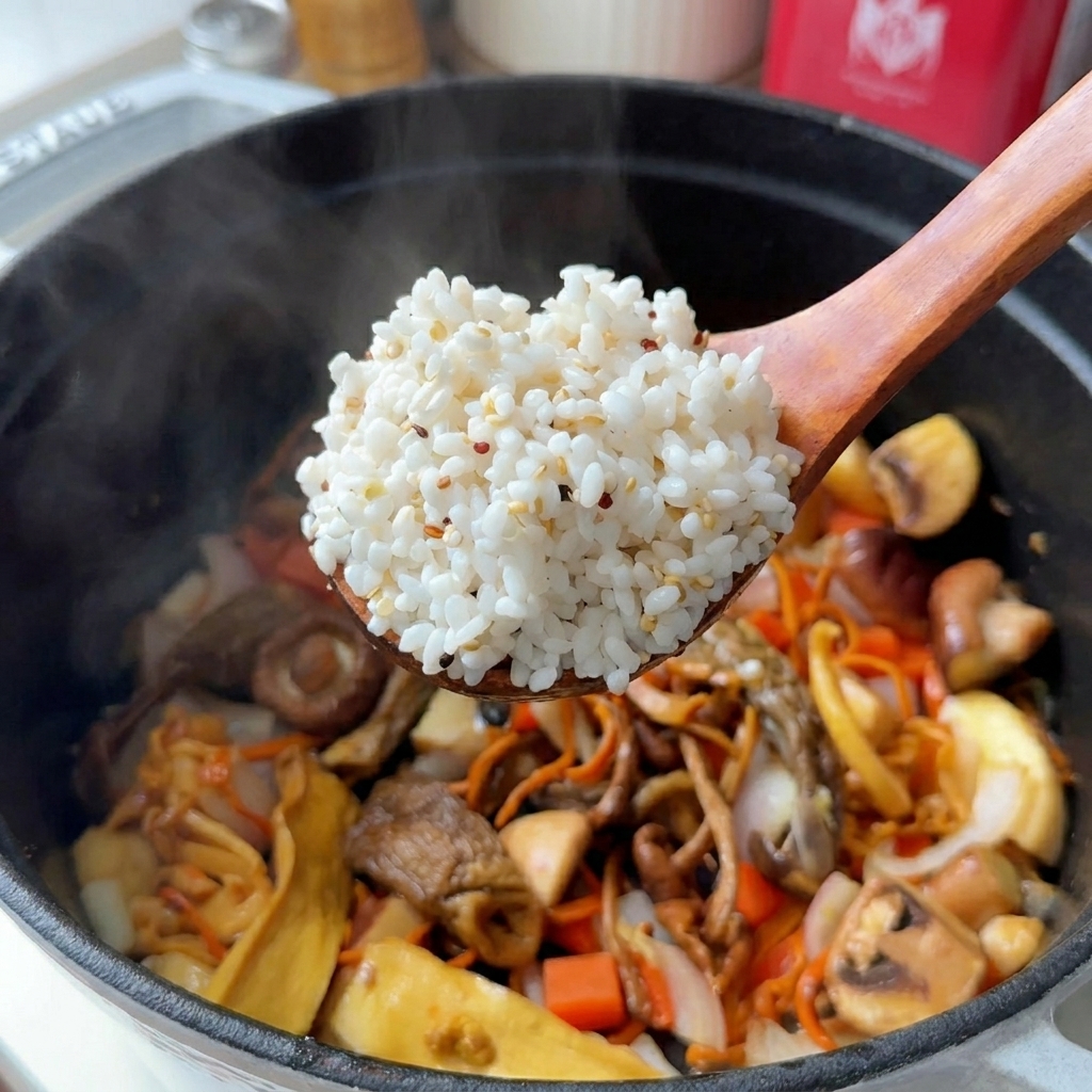 Ein Holzlöffel hebt eine Portion Reis und Quinoa über einen Topf mit Pilzen und Karotten.
