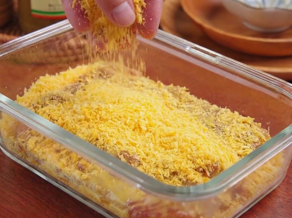 Gelbe Panko-Brotkrümel werden fest auf die Oberfläche des Fleisches gedrückt.