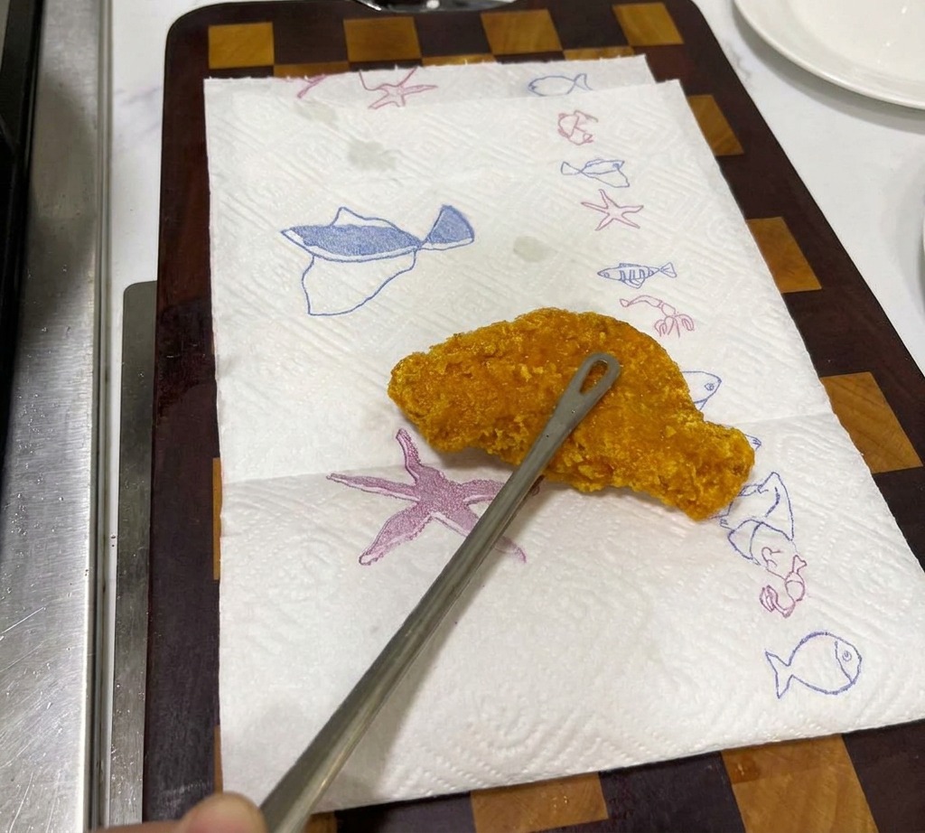 Das knusprig frittierte Hähnchen ruht auf Küchenpapier zum Abtropfen.
