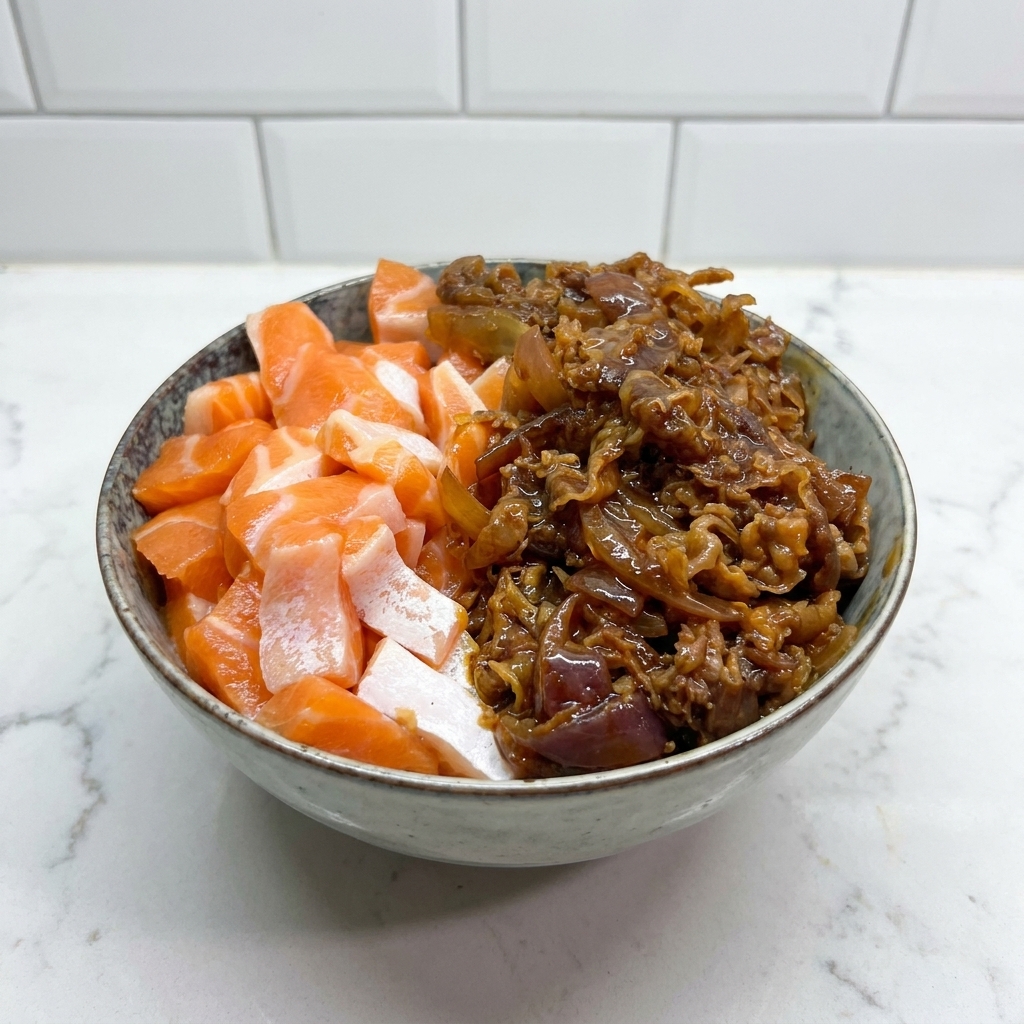 Eine Keramikschüssel mit rohem Lachs auf der linken und herzhaftem Rindfleisch auf der rechten Seite.