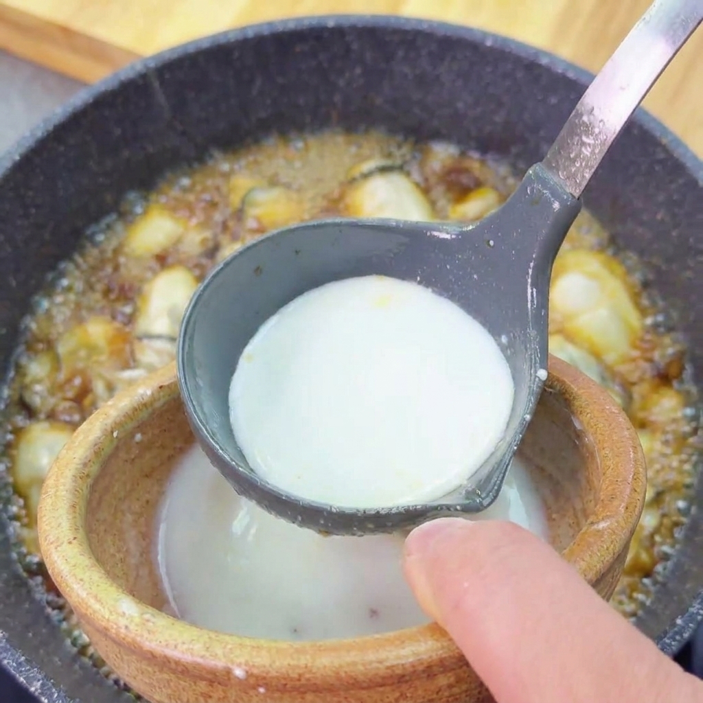 Eine milchig-weiße Kartoffelstärkemischung wird aus einer kleinen Schale in die Pfanne gegossen.