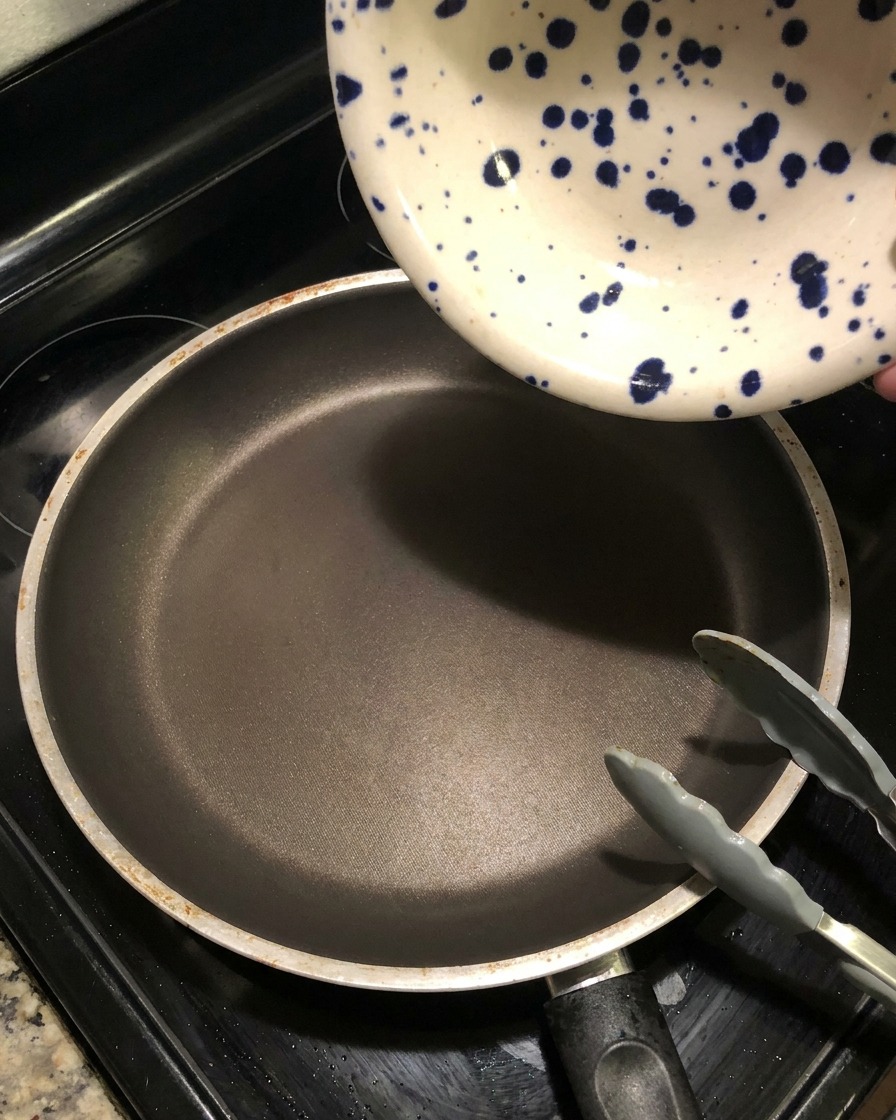 Restliche dunkle Marinade wird in eine heiße Pfanne gegossen, um sie einzukochen.