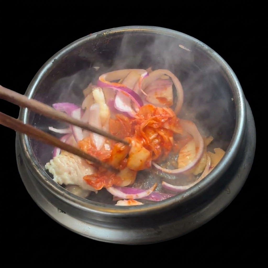 Eine Handvoll gehacktes rotes Kimchi wird zu Fleisch und Zwiebeln in den Topf gegeben.